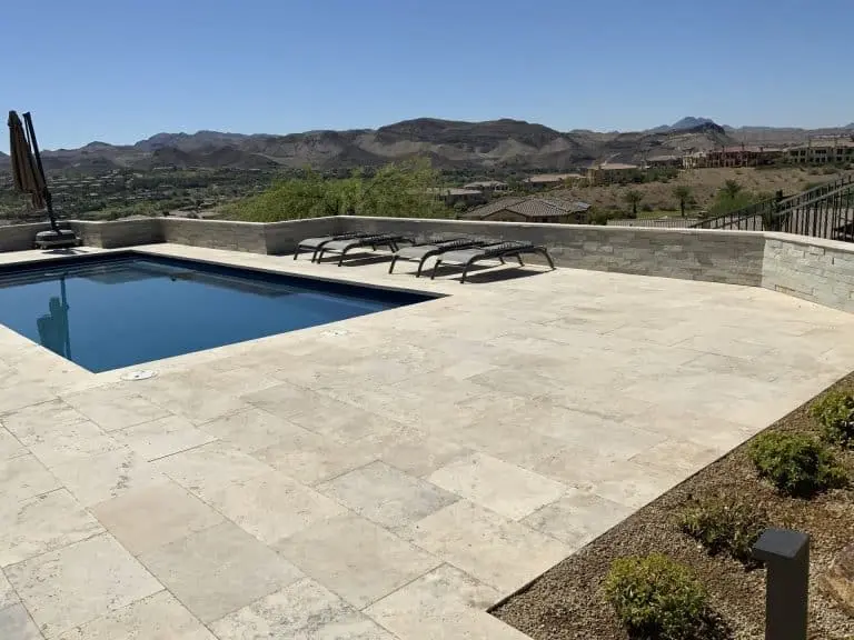 Paver pool deck in Las Vegas with cool-touch travertine coping