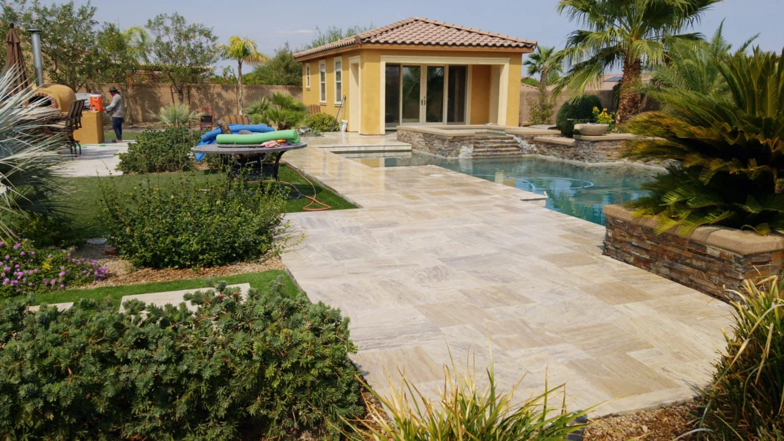 Paver pool deck in Las Vegas with a raised spa and spillover feature