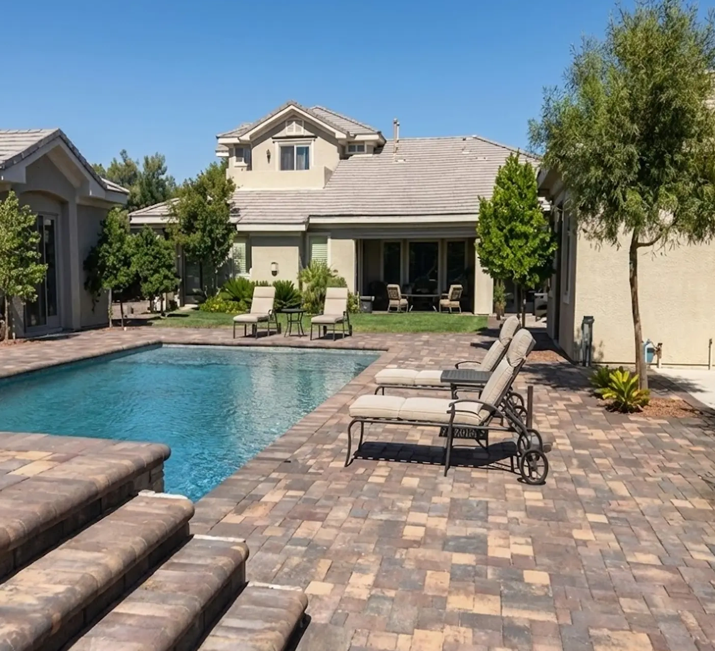 Paver pool deck in Las Vegas with a tanning ledge and lounge area