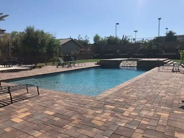 Paver pool deck in Las Vegas with cool-touch travertine coping