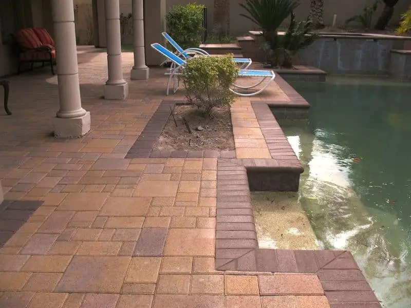 Paver pool deck in Las Vegas with a raised spa and spillover feature
