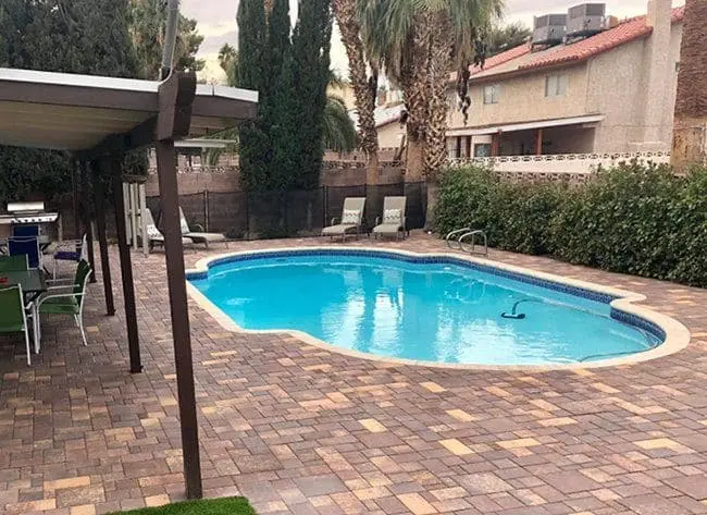 Paver pool deck in Las Vegas with a tanning ledge and lounge area